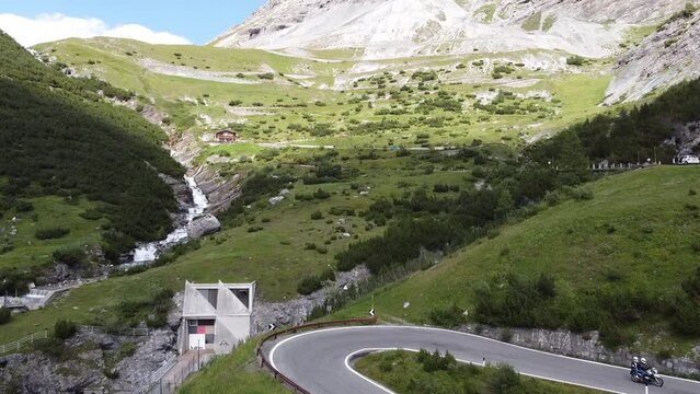 Stelvio Mountain Pass at South Tyrol, Italy - Aerial Drone View of a MotorCycle driving the Famous Road with Curves and Hairpins - Giro d' Italia Cycling Lap
