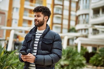 Young arab man using smartphone outdoor at the town