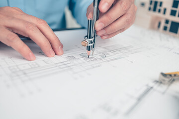 Architect engineer use compass drawing design working on blueprint. House planning design and...