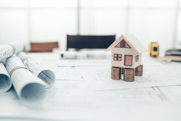 Mini model house, Money, pencil, compass  and roll blueprint plan  on blueprint house plan design....