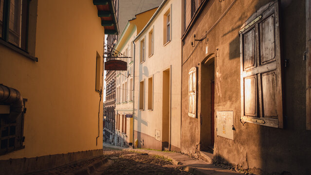 Beautiful shot of a street with old buildings and windows at night with lights in Cieszyn, Poland