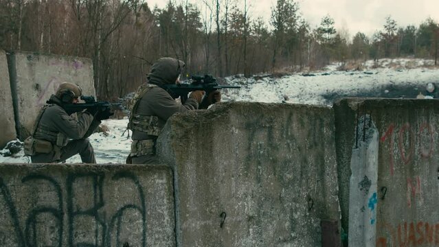 Military exercises of soldiers in a snowy forest. Shooting from a machine gun.