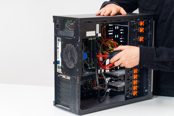 Service center employee dusting out a desktop computer