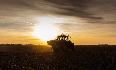 Naklejka premium Tractor spreading artificial fertilizers in field