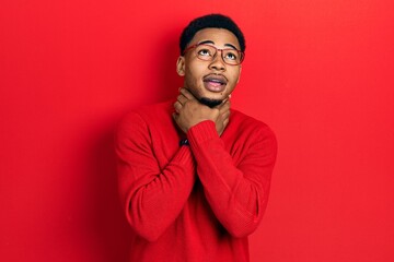 Young african american man wearing casual clothes and glasses shouting and suffocate because painful strangle. health problem. asphyxiate and suicide concept.