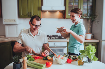 Father and son cook food at home and record videos for blog on social networks
