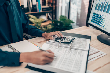 Investors working on desk office and using a calculator to calculate balance, projit, currency and...