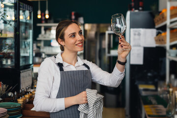 woman waitress polishing wine glass