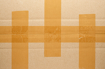 Brown tape on cardboard. The concept of transporting things, sending a donation or packing parcels. Copy space.