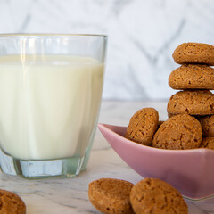 Amaretti cookies and glass of milk drink. Small soft Italian traditional sweet-bitter pastry dessert.
