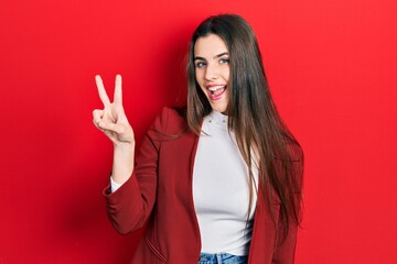 Young brunette teenager wearing business jacket showing and pointing up with fingers number two while smiling confident and happy.
