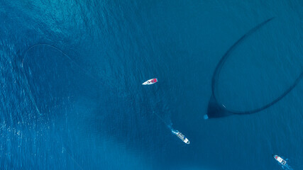 Aerial view of a few motorboat fishing with a net at El Golfo, Mediterranean Sea, Girona, Spain.