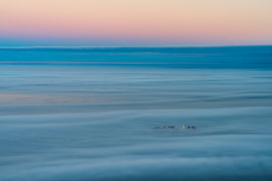 Aerial view of a cargo ship sailing goff Cape Town coastline during a foggy day, Cape Town, South Africa.