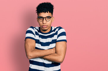 Young african american man wearing casual clothes and glasses skeptic and nervous, disapproving...