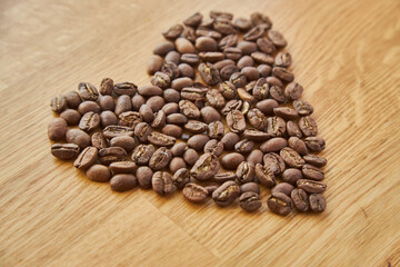 Closeup of heart shaped coffee beans, valentine heart of coffee, coffee grains. on wooden background