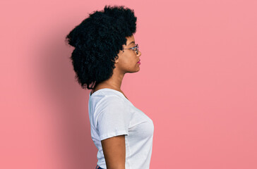 Young african american woman wearing casual white t shirt looking to side, relax profile pose with...
