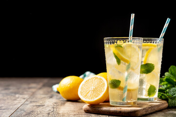 Glass of fresh lemonade on wooden table. Copy space