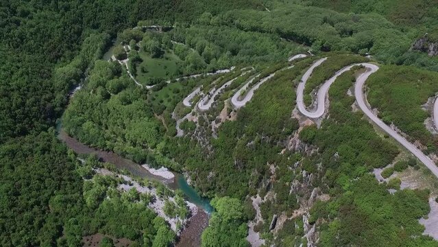 Drone shot. Supercars on a lot of turns heading into the mountain near Paingo, Greece.