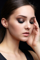 Obraz premium Beauty portrait of young woman. Brunette girl with evening female makeup and black dress
