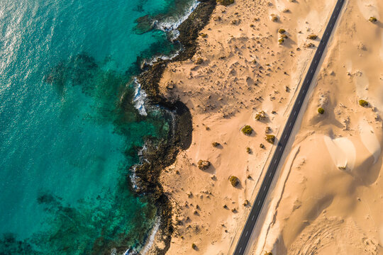 Aerial top down view of a road crossing the desert at Corralejo sand dunes natural park, Fuerteventura, Canary Islands, Spain.