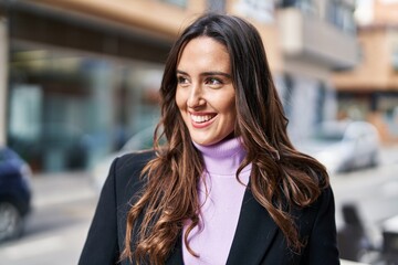 Naklejka premium Young hispanic woman smiling confident standing at street