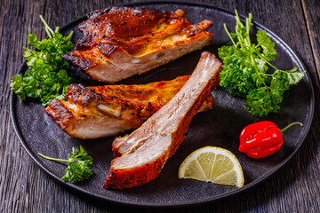 juicy roast pork ribs on plate, top view
