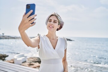 Young caucasian girl smiling happy making selfie by the smartphone at the beach.