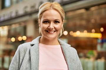 Fototapeta premium Young blonde businesswoman smiling happy standing at the city.