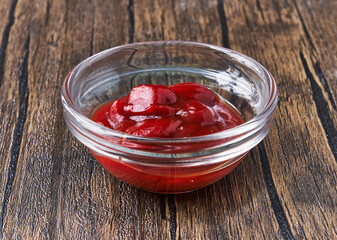  Bowl of tomato sauce on wooden surface