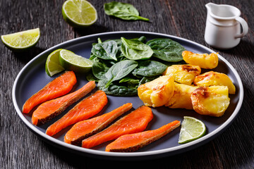 salmon slices with spinach leaves, roast potatoes
