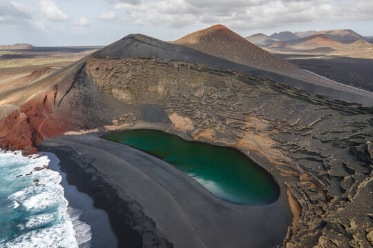 Aerial panoramic view of El Lago Verde (Green Lake) along the coast with black sand beach near El Golfo, Lanzarote, Canary Islands, Spain.