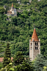 The bell tower of the  Santo Stefano church in Mori. In the background the sanctuary of Santa Maria...