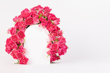 Spring abstract stage with framing of arch of pink fresh spray roses mockup on white background,...