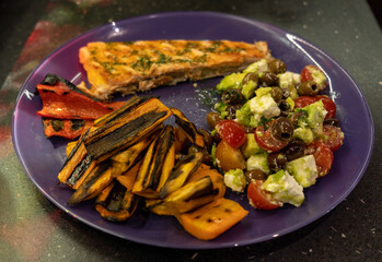 Delicious homemade grilled salmon fillet with side of roasted sweet potato, paprika and mini tomato cheese salad