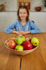 Little happy girl hold bowl with fruits in the kitchen at home, healthy child snack