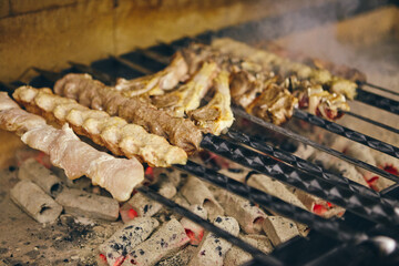 Shish kebab on skewers from different types of meat is fried on the grill