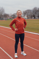 Obraz premium Young fitness woman running at a track and field stadium
