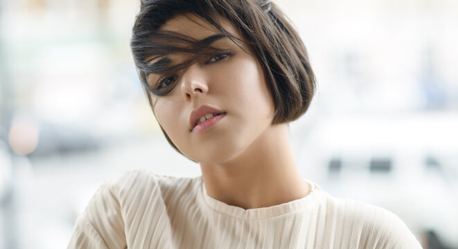 Portrait of beautiful young woman with brown eyes and short hair.