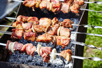 Marinated shashlik preparing on a barbecue grill over charcoal. Traditional Russian shashlik on a barbecue skewer