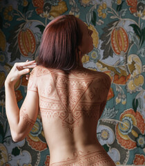 Beautiful woman with tattoo on her back.