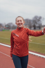 sporty charming girl does a warm-up at the stadium going to run