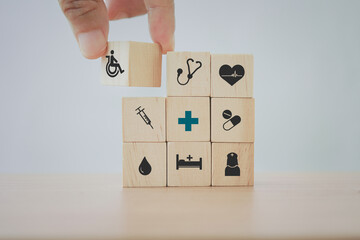 hand arrange health and medical icon on wooden cube blocks for wellness, wellbeing for disabled person or aging people