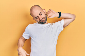 Young bald man wearing casual white t shirt stretching back, tired and relaxed, sleepy and yawning...