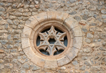Fototapeta na wymiar Ancient stone cross window on church in Ibiza