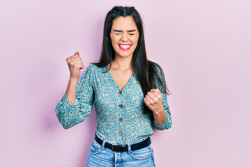 Young hispanic girl wearing casual clothes celebrating surprised and amazed for success with arms raised and eyes closed