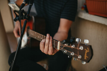 Mid adult man playing acoustic guitar and singing.