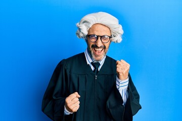 Middle age hispanic man wearing judge uniform celebrating surprised and amazed for success with...