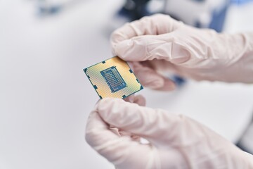 Young woman scientist holding cpu processor at laboratory