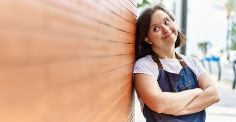Young down syndrome woman smiling confident wearing apron at street