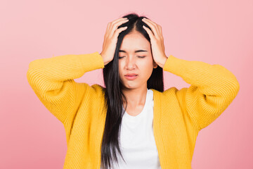 Portrait of beautiful Asian young woman sad tired strain face holding hold head by hands, female person closed eyes problem she headache, studio shot isolated on pink background